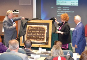 As BGCO Board members look on, Anthony Jordan, left, presents a wall hanging to Jo and Gene Downing, showing appreciation to the Downings for their $2.3 million gift toward work at Falls Creek.