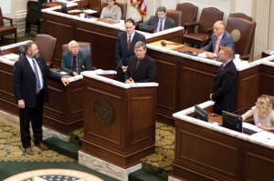 CAPITOL HONOR: Awe Star Ministries President Walker Moore, at podium, makes comments after being honored by the Oklahoma House of Representatives April 17. The effort was led by State Rep. Wade Rousselot, standing left, in recognition of Moore’s carrying a cross to the top of Mt. Kilimanjaro last year.